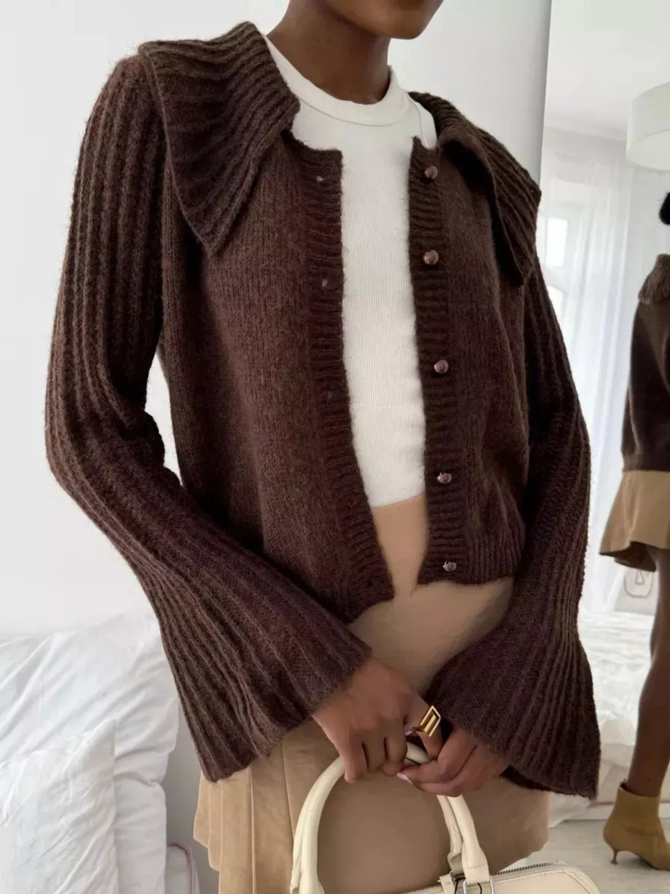 Button Up Flare Sleeve Cardigan worn by a woman, featuring a brown color and ribbed texture, paired with a white top.