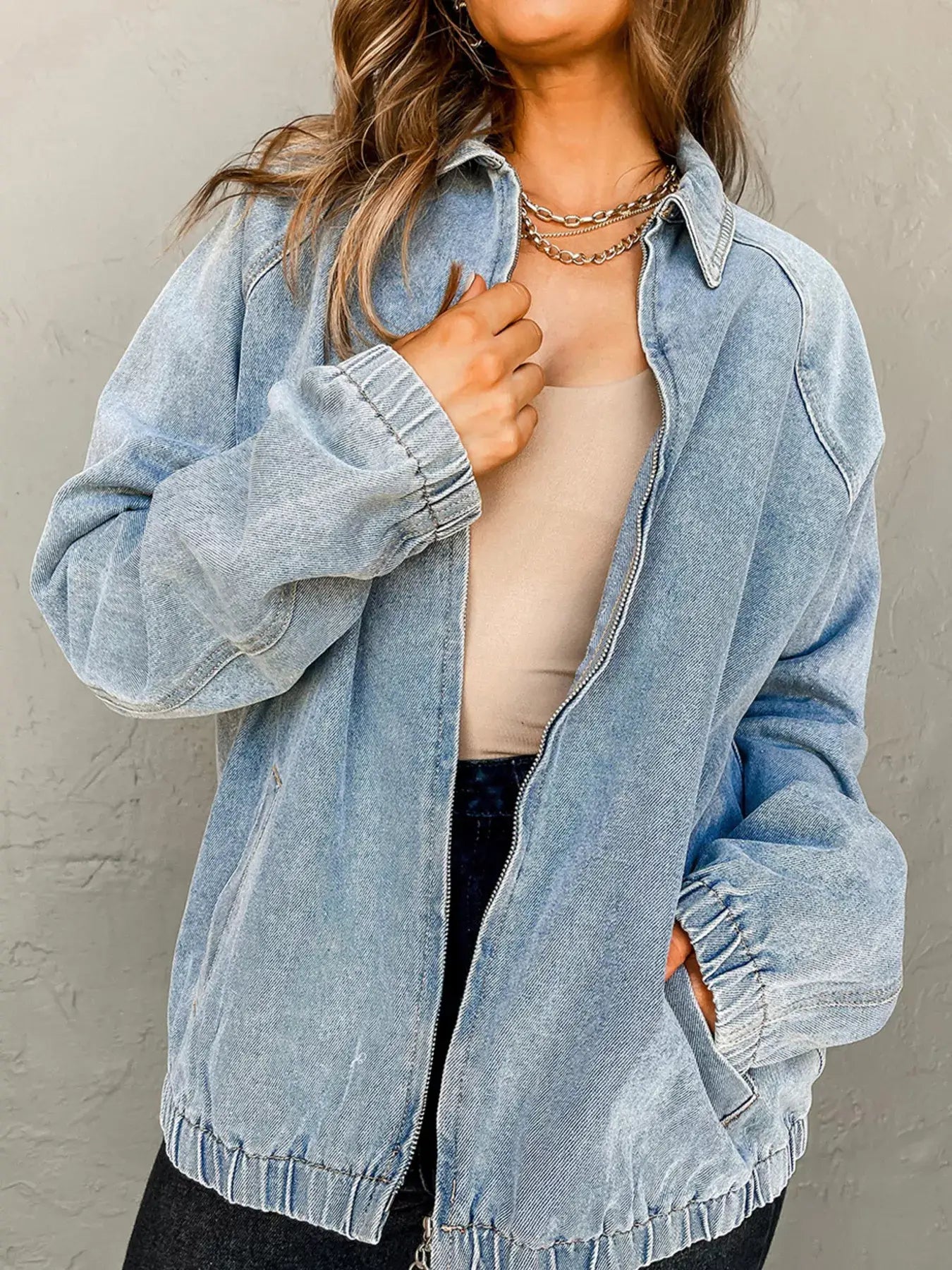 Model wearing an Elastic Edge Collared Zip Up Denim Jacket in light blue with a functional pocket.