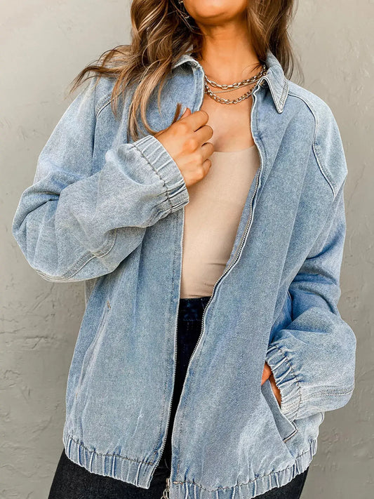 Model wearing an Elastic Edge Collared Zip Up Denim Jacket in light blue with a functional pocket.
