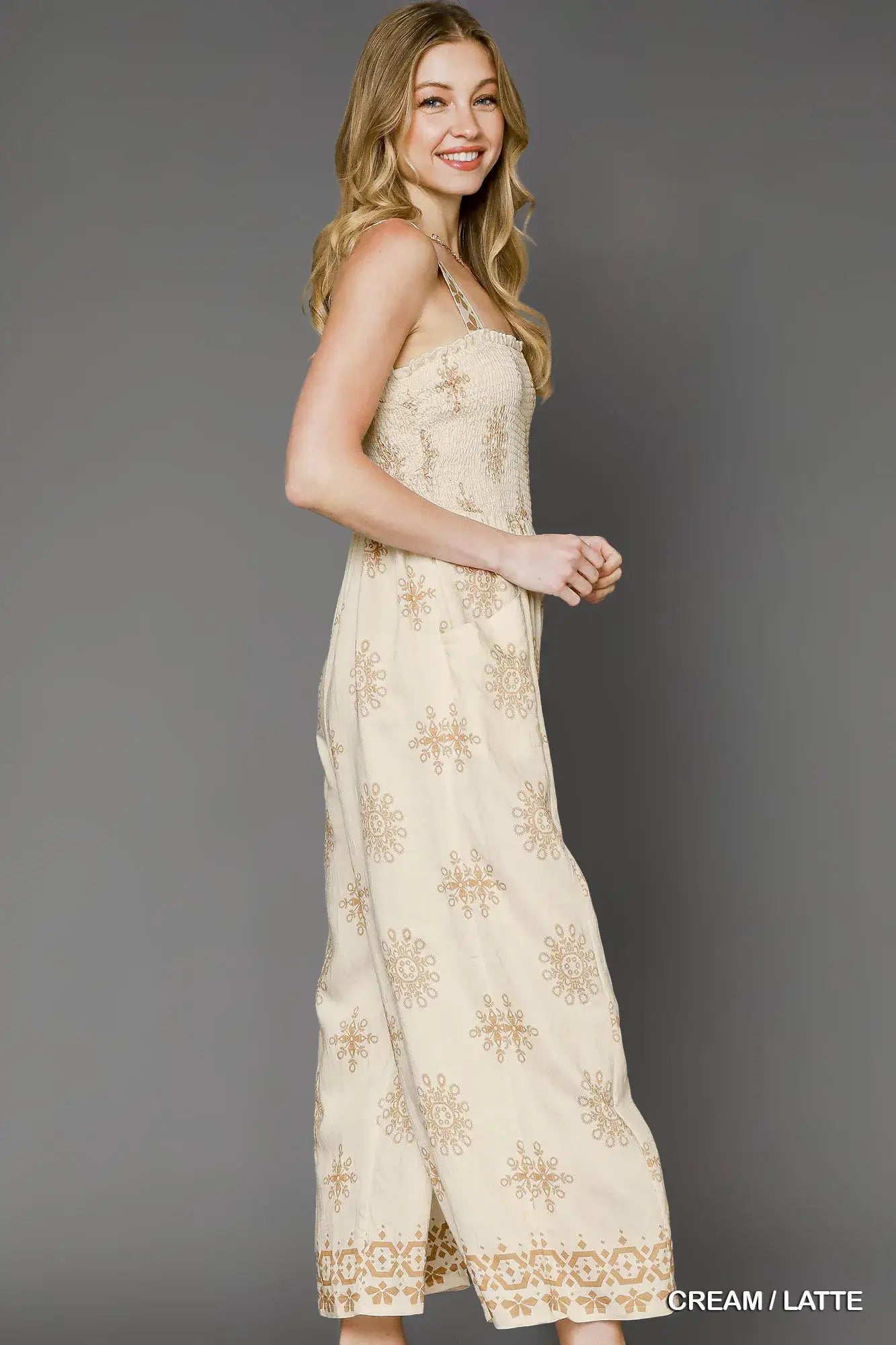 Umgee Smocked Printed Wide Leg Jumpsuit in cream and latte floral print, showcasing a sleeveless design and wide-leg silhouette.