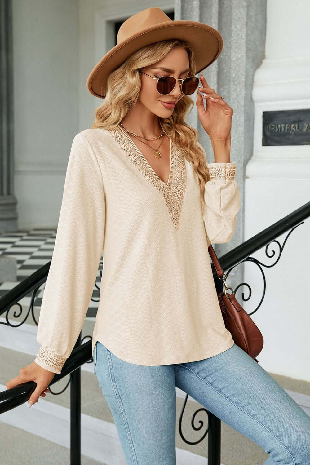 V-Neck Long Sleeve Blouse in cream color, paired with jeans, stylish hat, and sunglasses for a casual and elegant look.