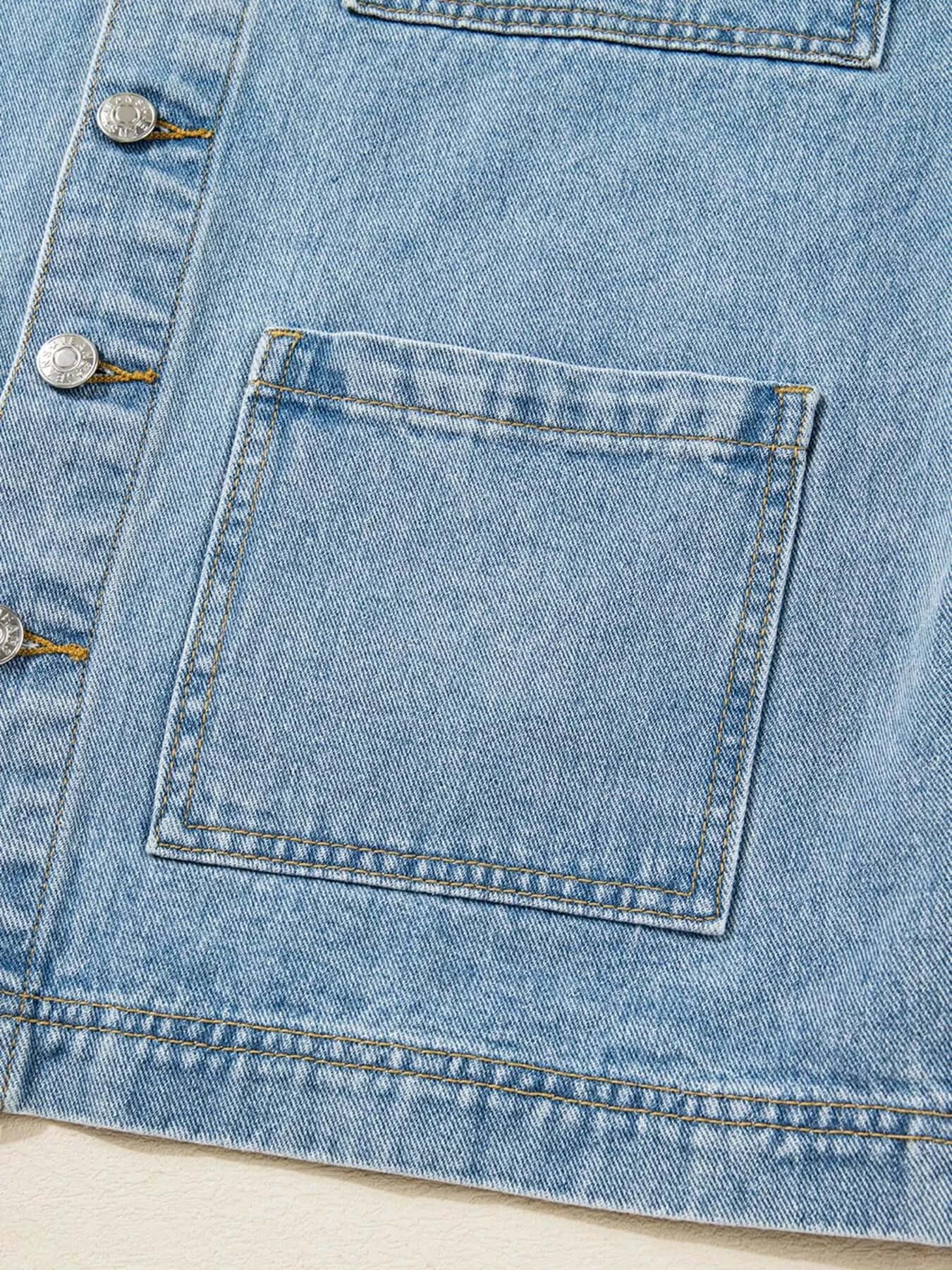 Close-up of patched pocket on a blue denim jacket, showcasing stylish design and button details.