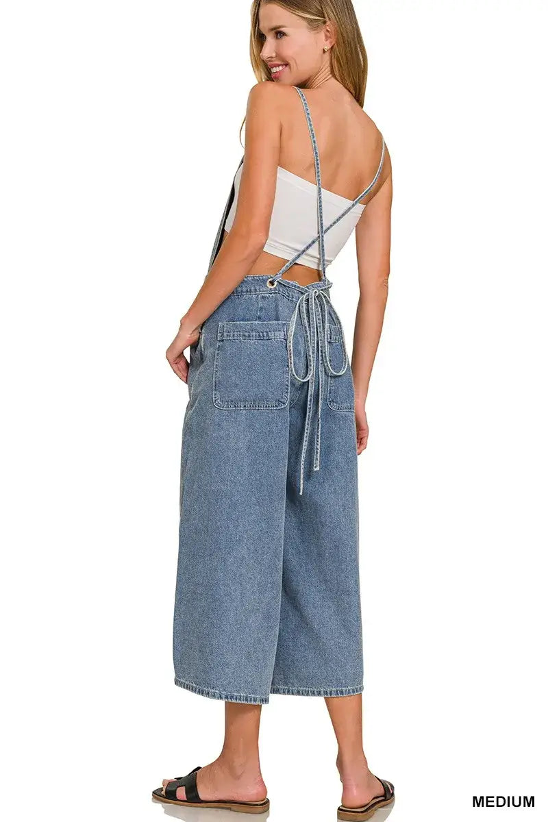 Woman wearing Zenana Denim Wide Leg Overalls in medium wash, showcasing a relaxed fit with functional pockets.