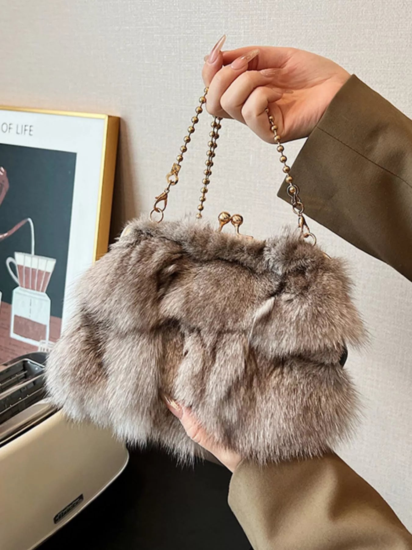 A person holding a stylish Furry Chain Crossbody Bag made of fox fur, perfect for trendy casual looks.