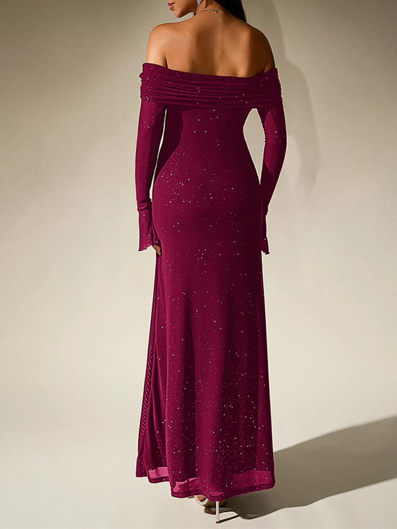 Back view of a woman wearing a Glitter Off-Shoulder Maxi Dress showcasing its elegant design and glitter details.