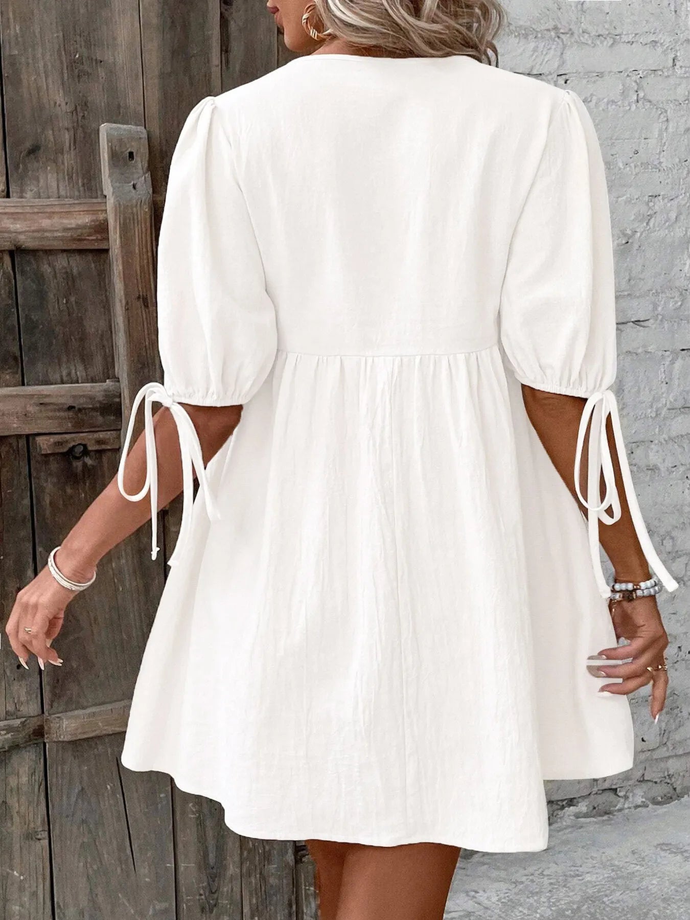 Back view of a V-Neck Tie-Front Mini Dress with Puff Sleeves, showcasing a white design and tied details.