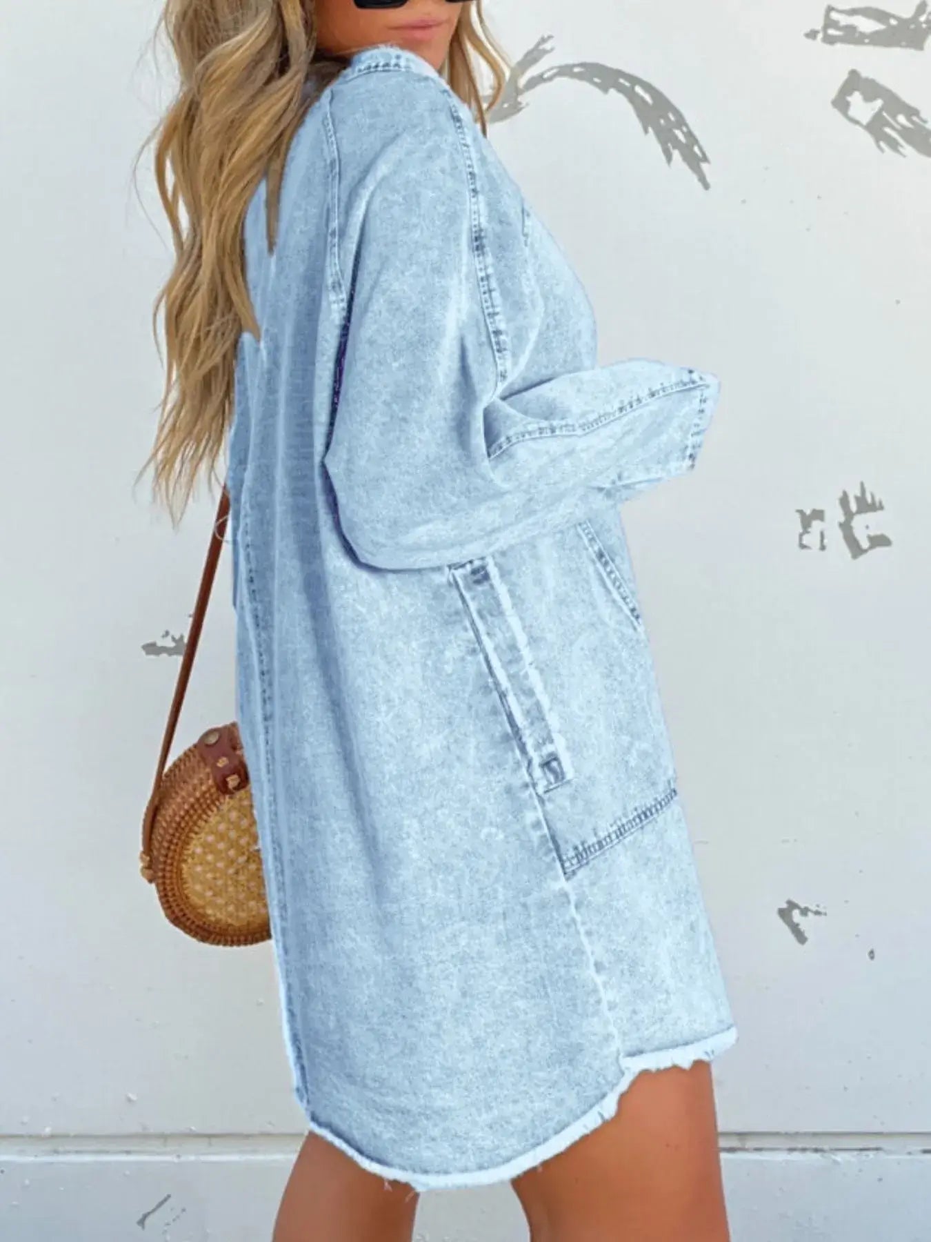 Model wearing a light blue button-front long sleeve denim shirt dress with a relaxed fit and functional pockets.