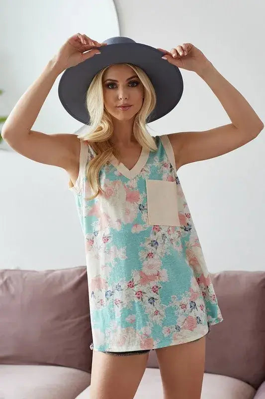 Woman wearing BiBi Multi Color Flower Printed Tank with Contrast Band, posing with a stylish hat.