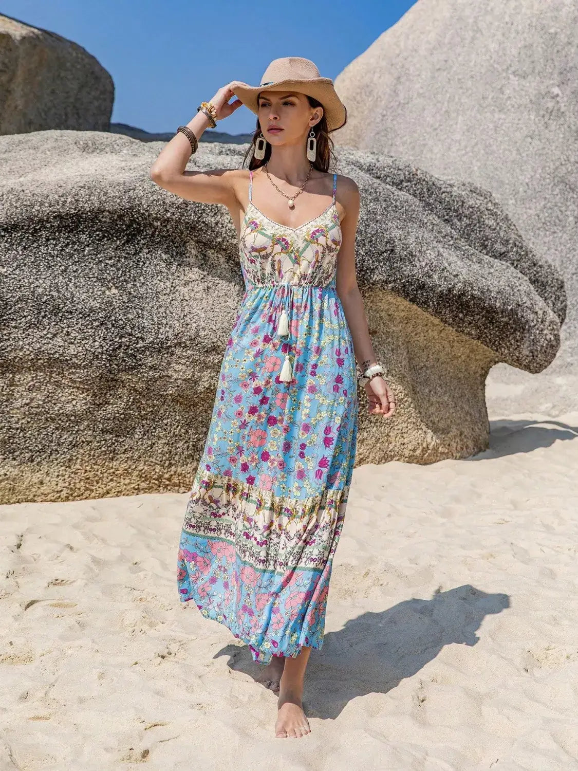 Model wearing a Tassel Floral Print Cami Dress on the beach, showcasing its bohemian style and vibrant colors.