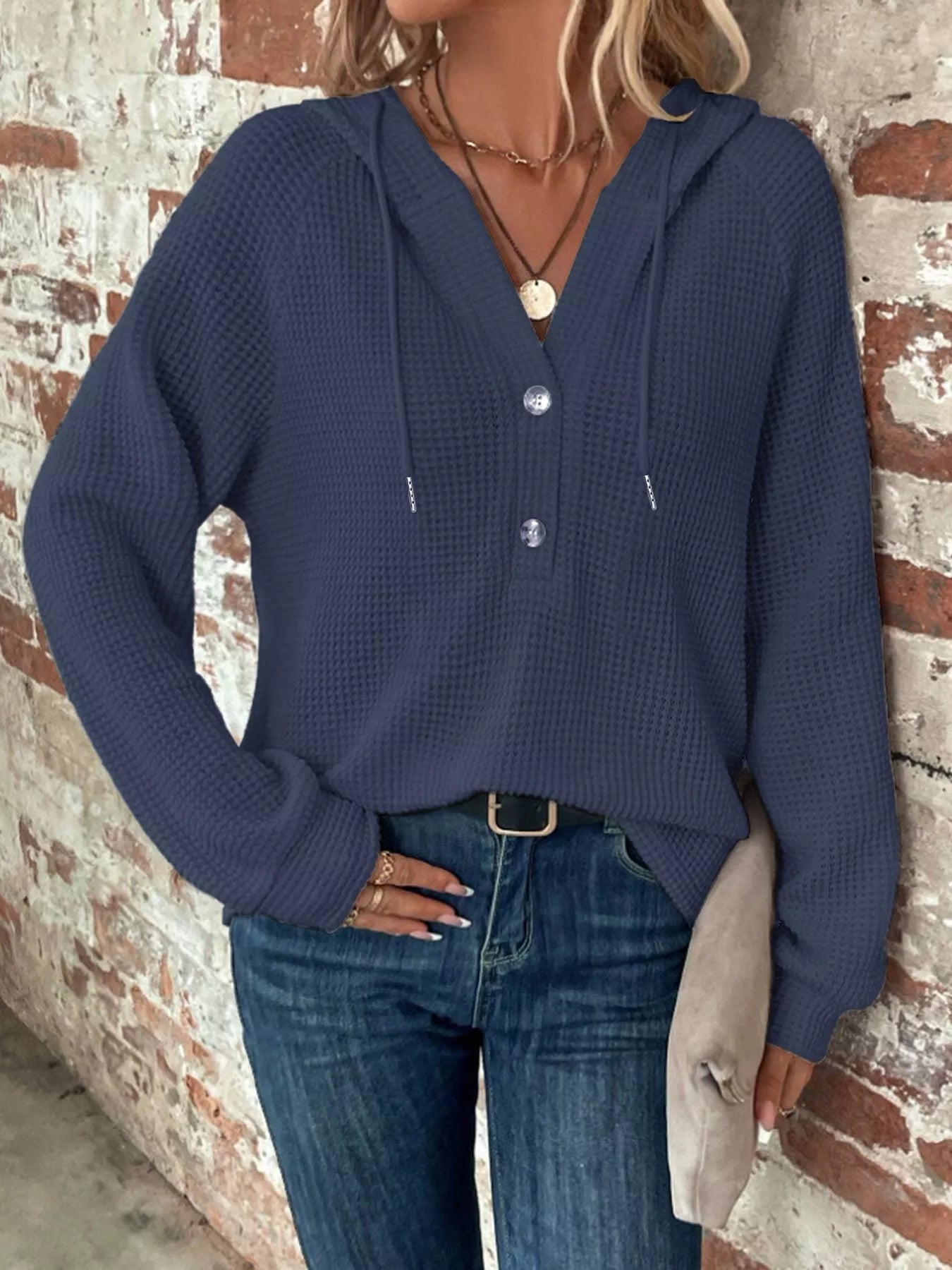 Full Size Button Detail Waffle Knit Hoodie Plus Size worn with jeans in front of a rustic brick wall.