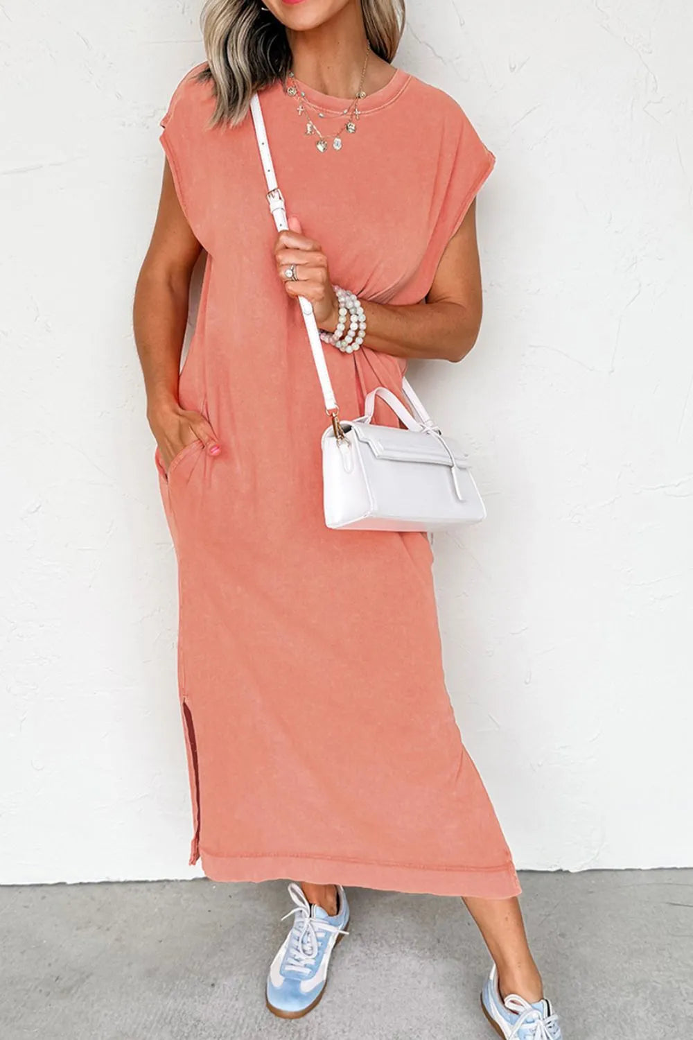 Woman wearing a Side Split Round Neck Cap Sleeve T-Shirt Dress, styled with a white handbag and sneakers.