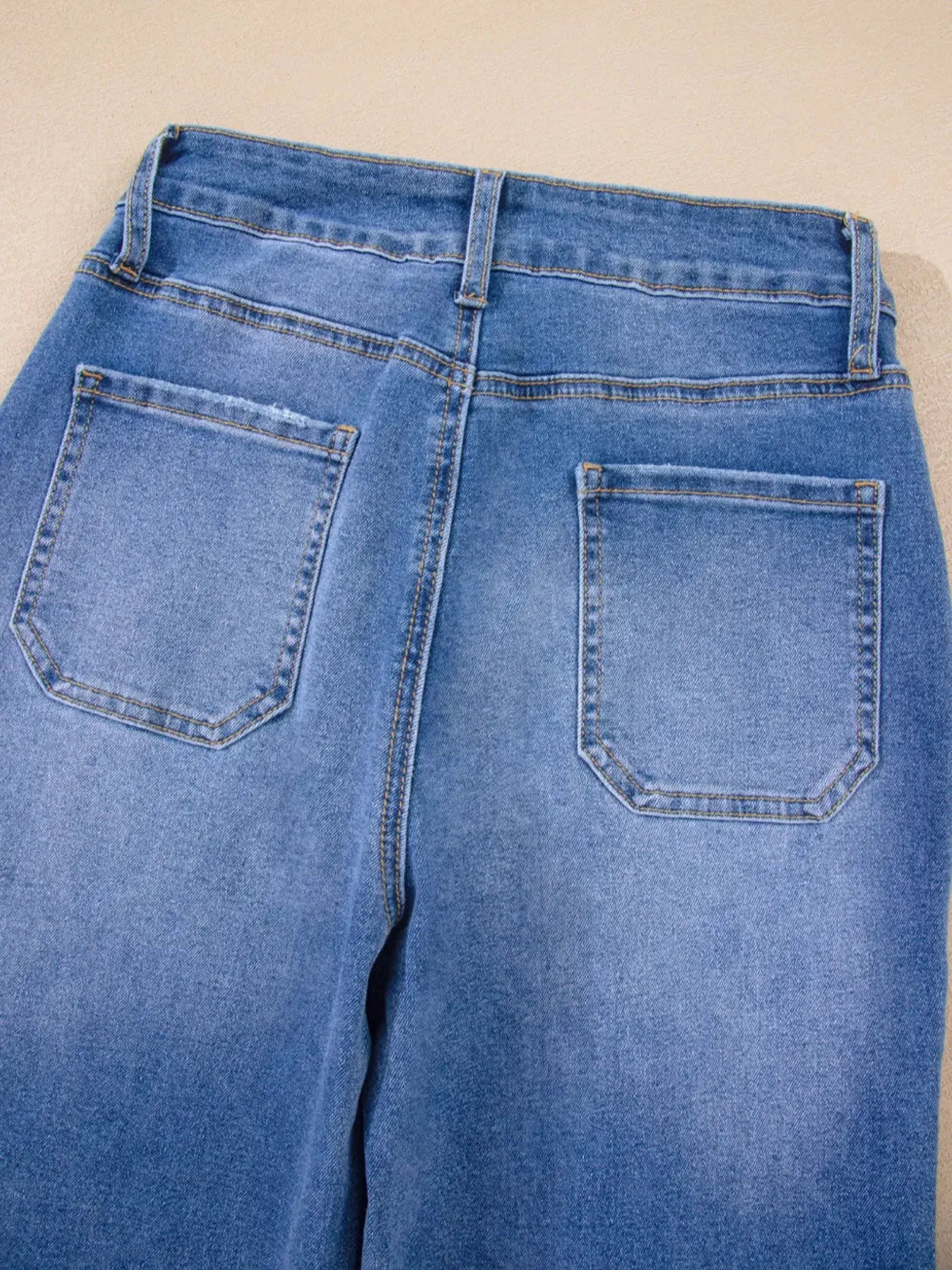 View of the back pockets and waistband of High-Waisted Wide Leg Flare Jeans in light blue denim.
