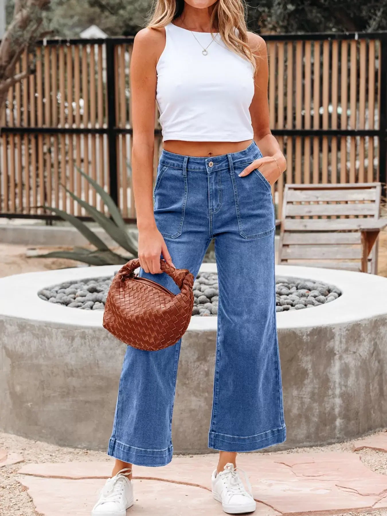 High-Waisted Wide Leg Flare Jeans styled with a white crop top and a brown bag, ideal for trendy looks.