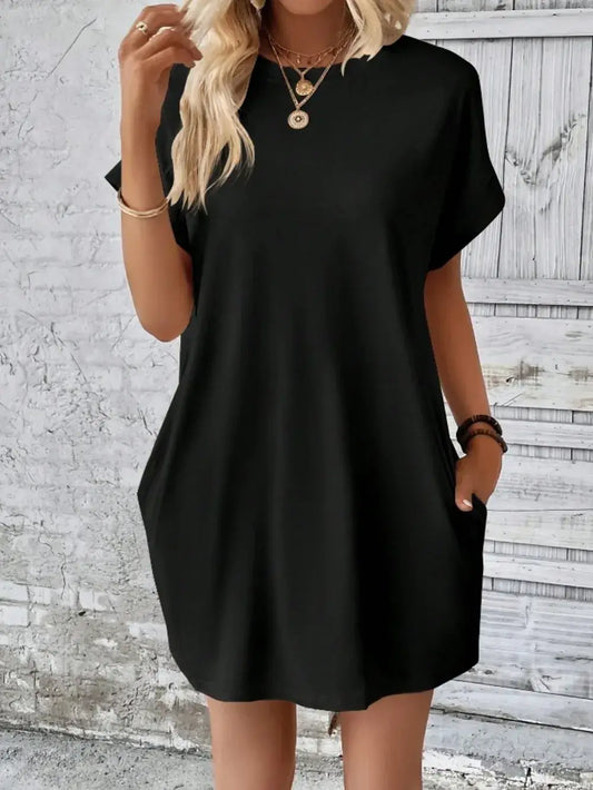 Model wearing a black pocketed round neck short sleeve dress, showcasing casual style and comfort.