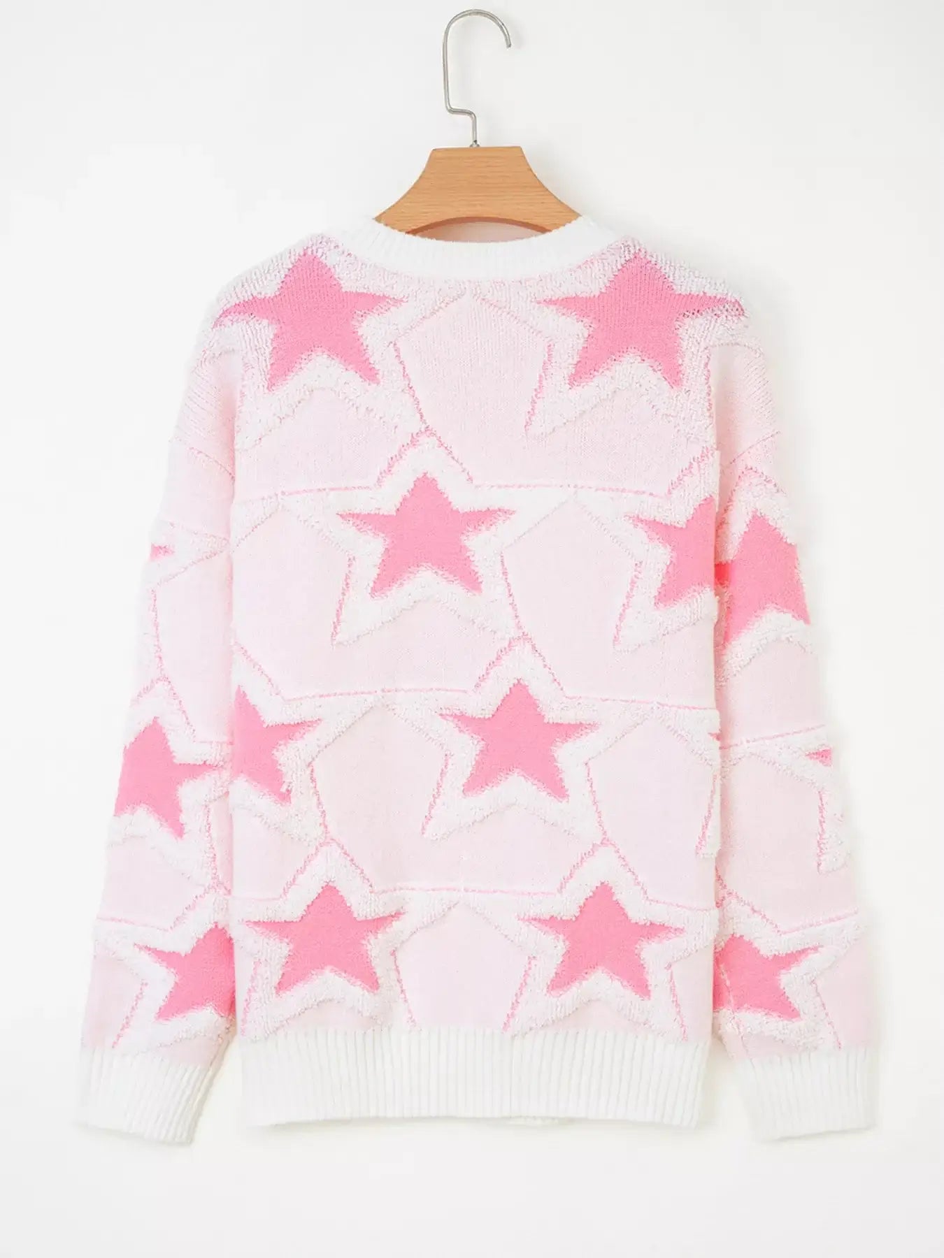 Oversized star pattern ribbed edge drop shoulder sweater in pink with star design on a hanger.