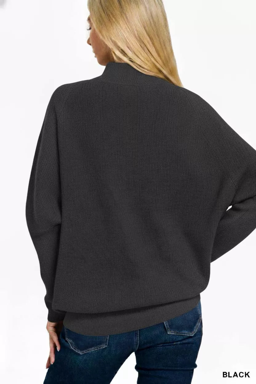 Back view of a model wearing the Zenana Viscose Dolman Sleeve Mock Neck Sweater in black, showcasing its relaxed silhouette.