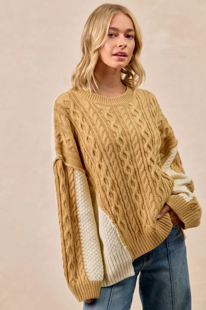 Model wearing BiBi Cable Knit Hacci Combo Sweater with uneven hem in beige and cream color.