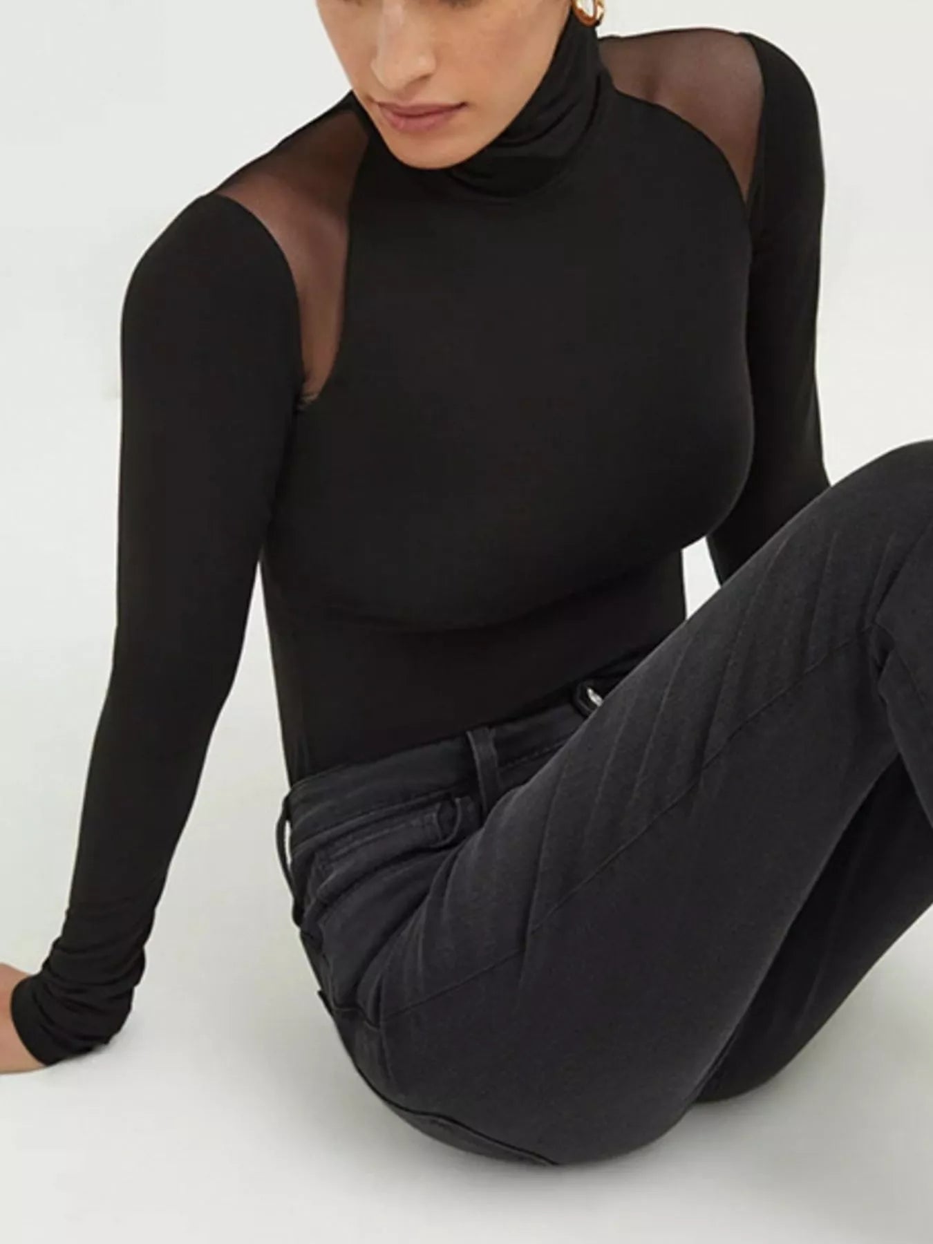 Model wearing a sleek Mesh Shoulder Turtleneck Bodysuit, showcasing modern elegance with sheer details.