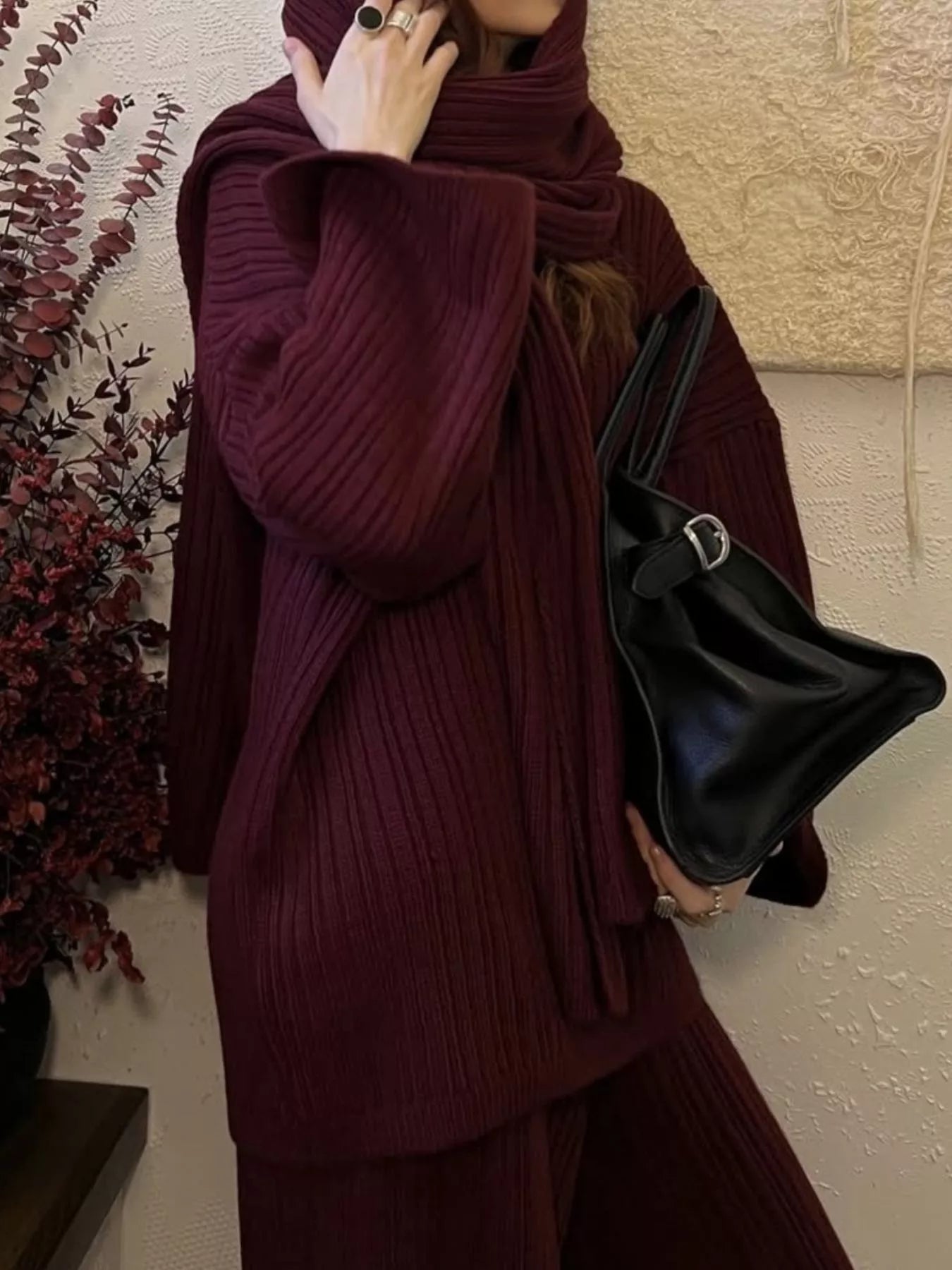 Model wearing a 3 Piece Ribbed Sweater and Wide Leg Pants Set with Scarf in burgundy, holding a black handbag.