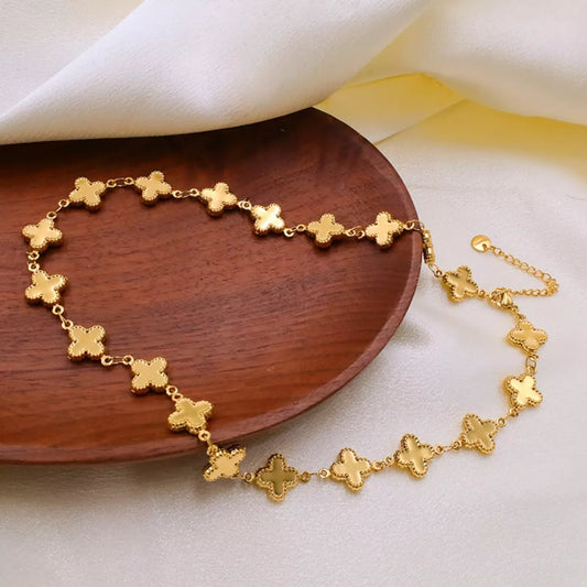 18K Gold-Plated Clover Charm Necklace displayed elegantly on a wooden plate.