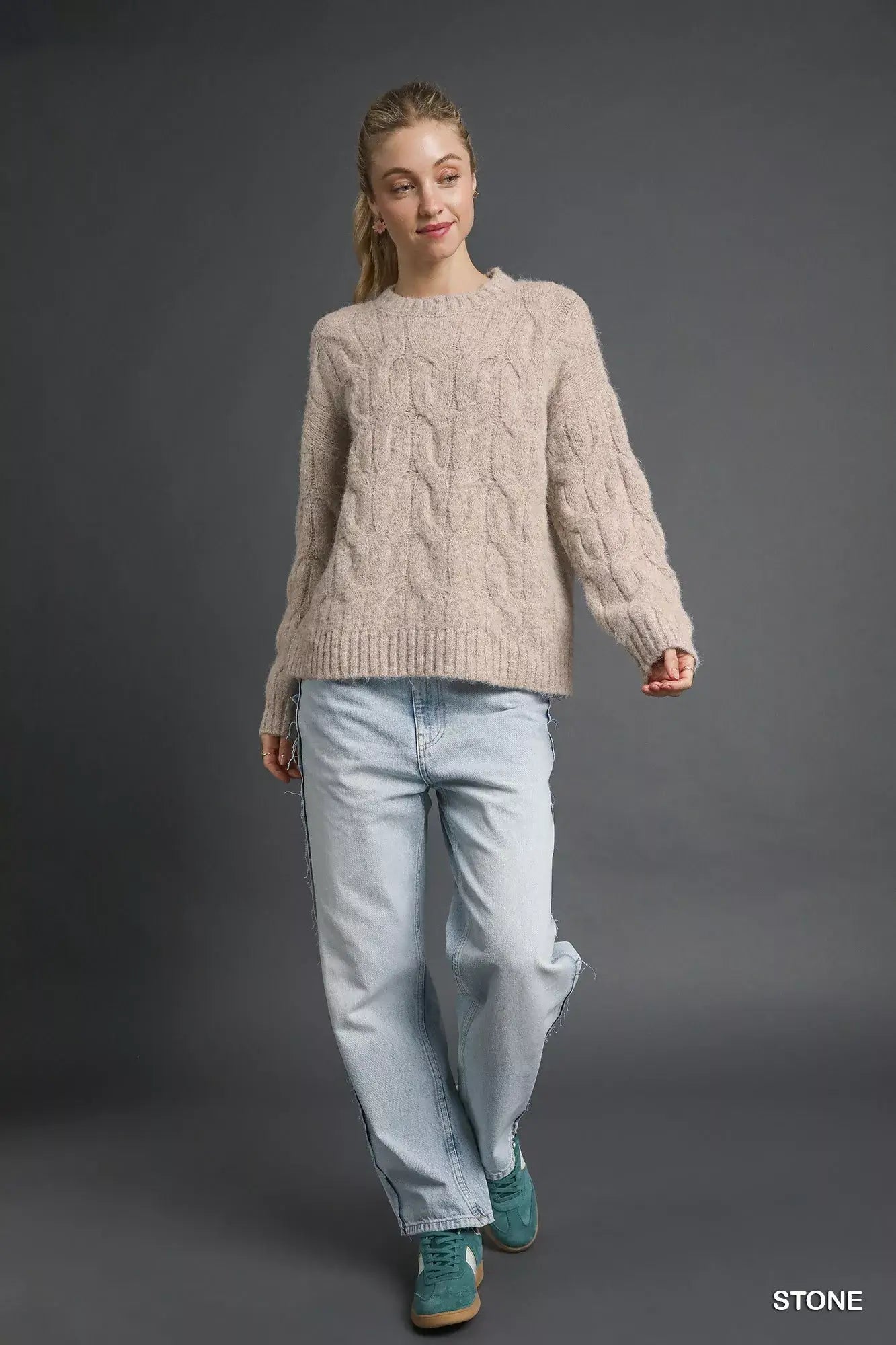 Umgee Cable Knit Cozy Sweater styled with light-wash jeans and boots for a chic winter look.