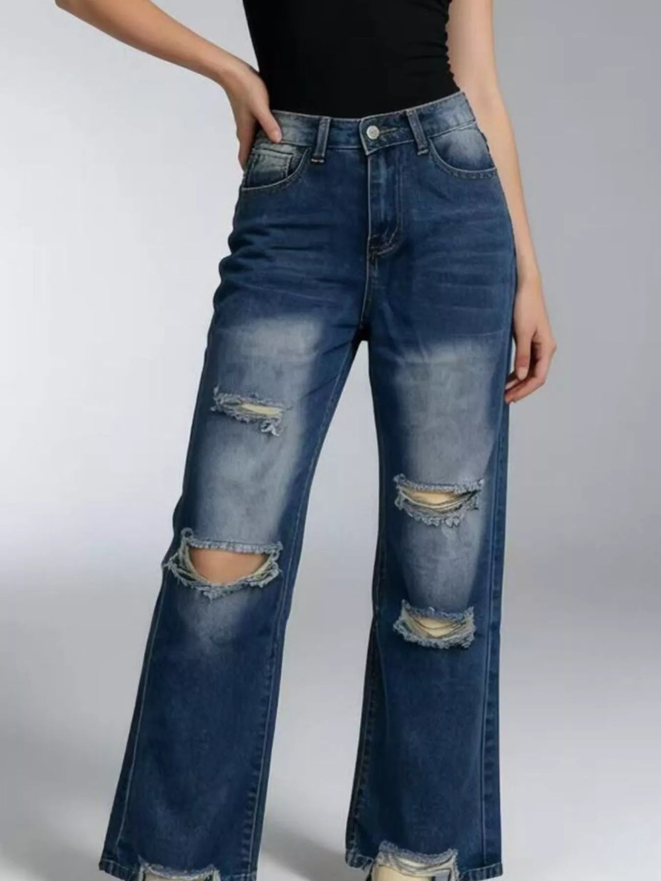 Distressed Wide Leg Jeans with buttoned pocketed design, featuring ripped details for a trendy look.