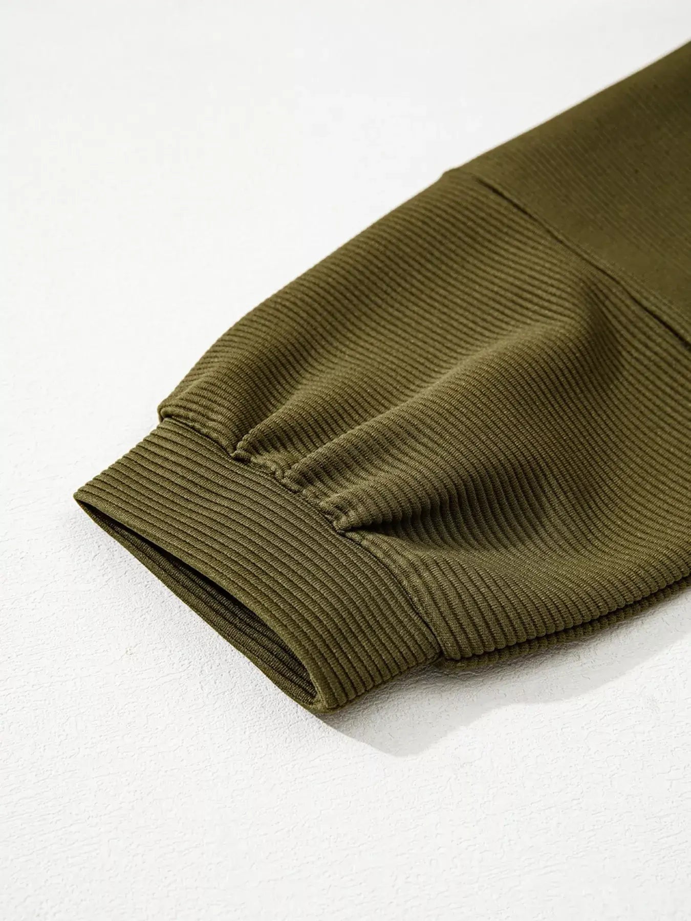 Close-up of ribbed knit sleeve of the Ribbed Knit Oversized Sweatshirt in olive green.