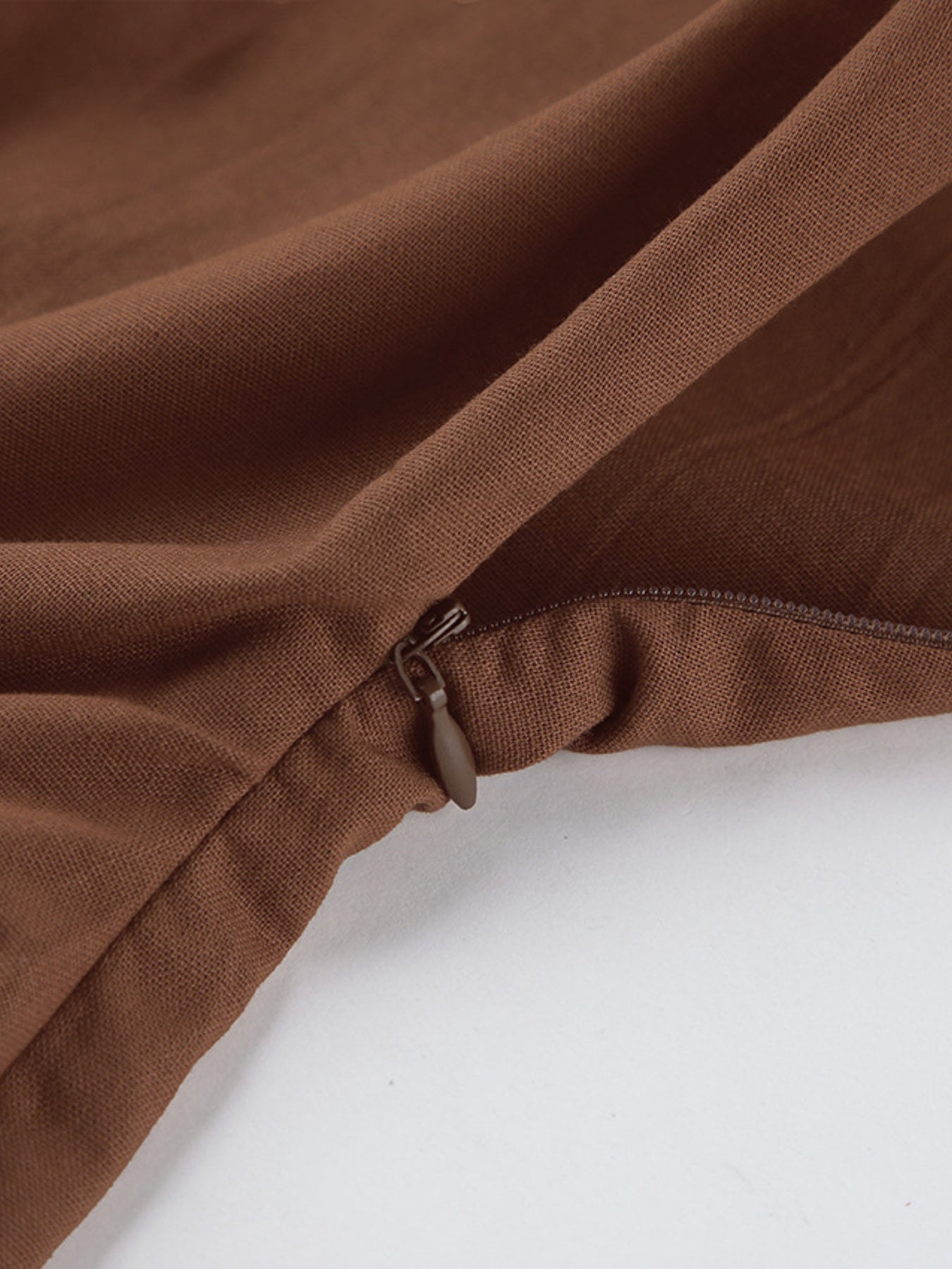 Close-up of the zipper detail on the One Shoulder Top and Shorts Set stylish asymmetrical outfit in brown.