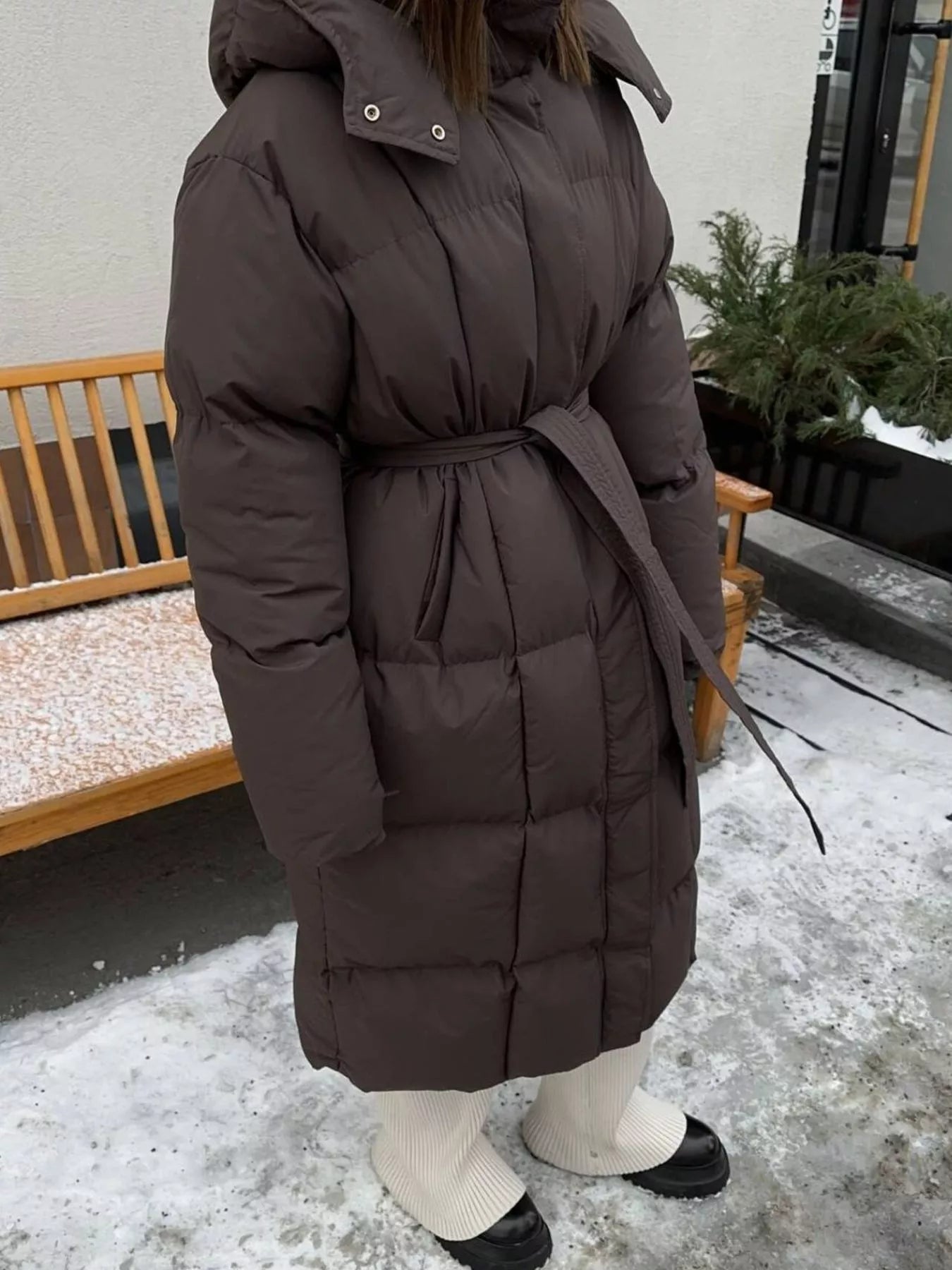 Longline Padded Winter Coat Belted worn by a woman outdoors, featuring a cozy design and stylish belt.