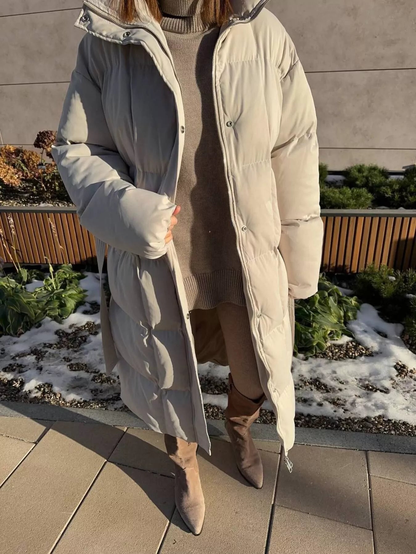 Longline Padded Winter Coat Belted warm women jacket shown in a stylish outdoor setting with a model wearing it.