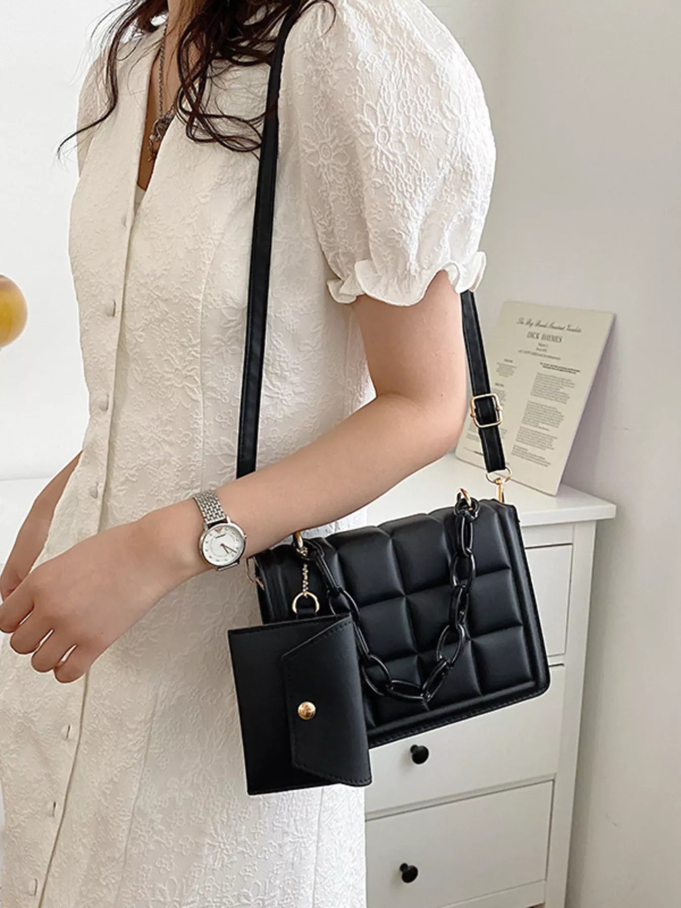 Quilted Chain Strap Crossbody Bag displayed on a model wearing a white dress with puff sleeves.