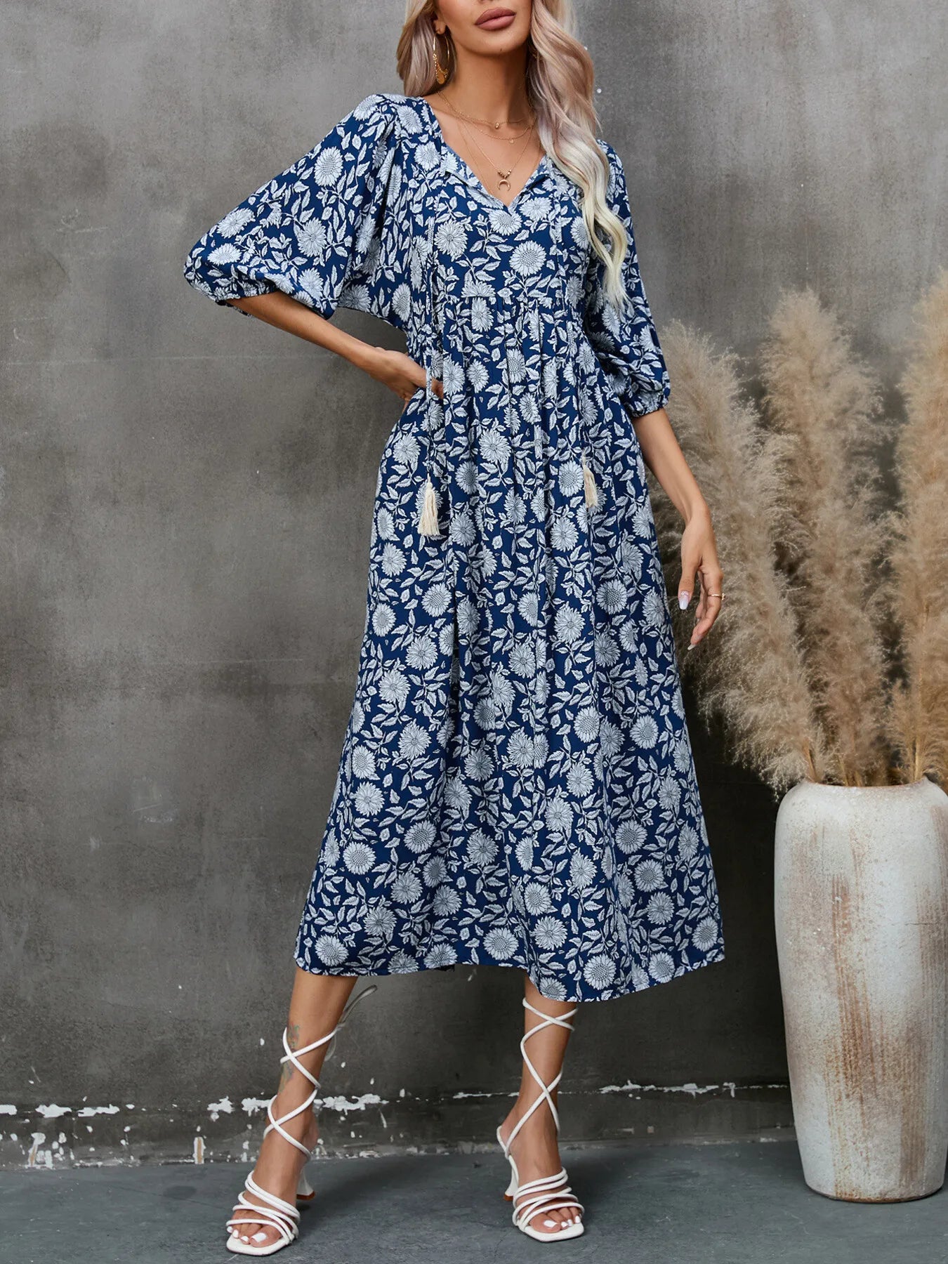 Printed Tie Neck Midi Dress in blue floral pattern, featuring ruched design and tassels, styled with strappy heels.