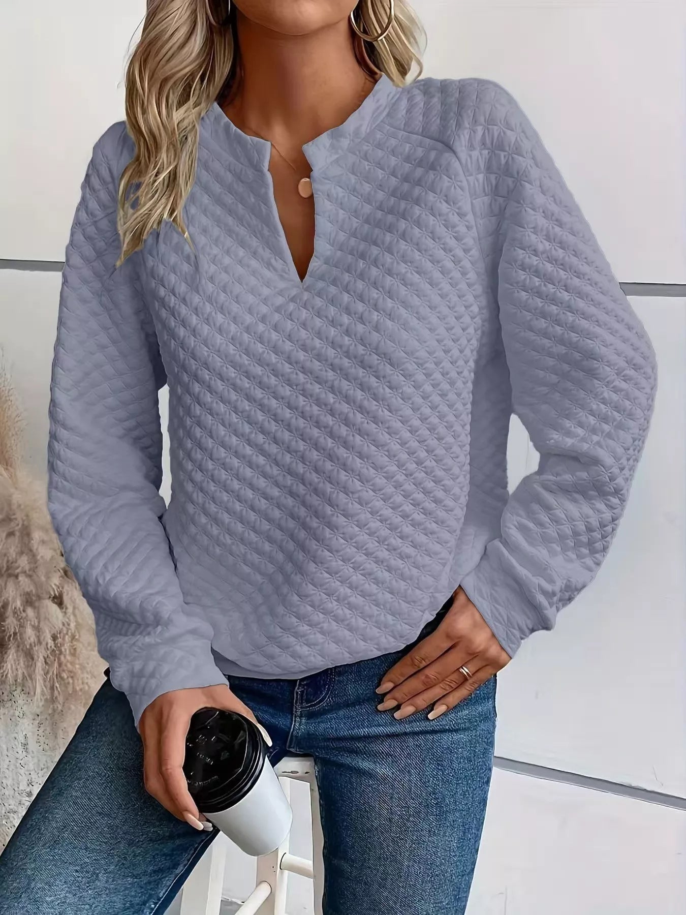 Quilted Texture Long Sleeve Sweatshirt with Notched Neck styled with jeans and holding a coffee cup.