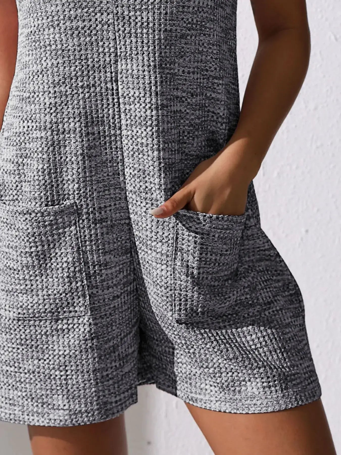 Full Size Button Front Romper with Pockets featuring functional pockets and a textured fabric.