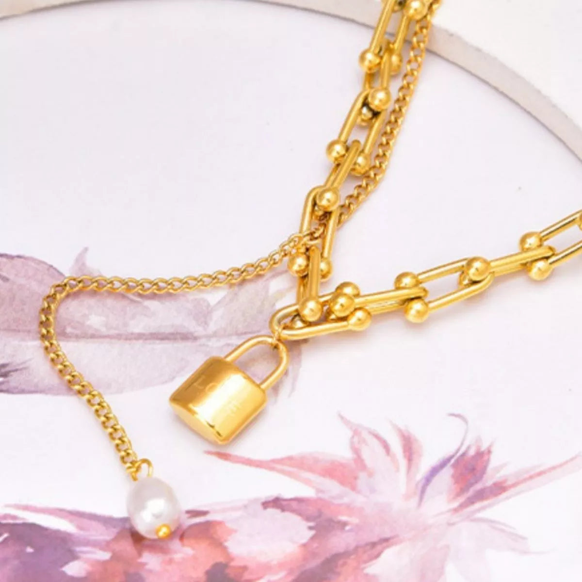 Close-up of an 18K Gold-Plated Lock Pendant Necklace featuring a delicate chain with synthetic pearl accents.
