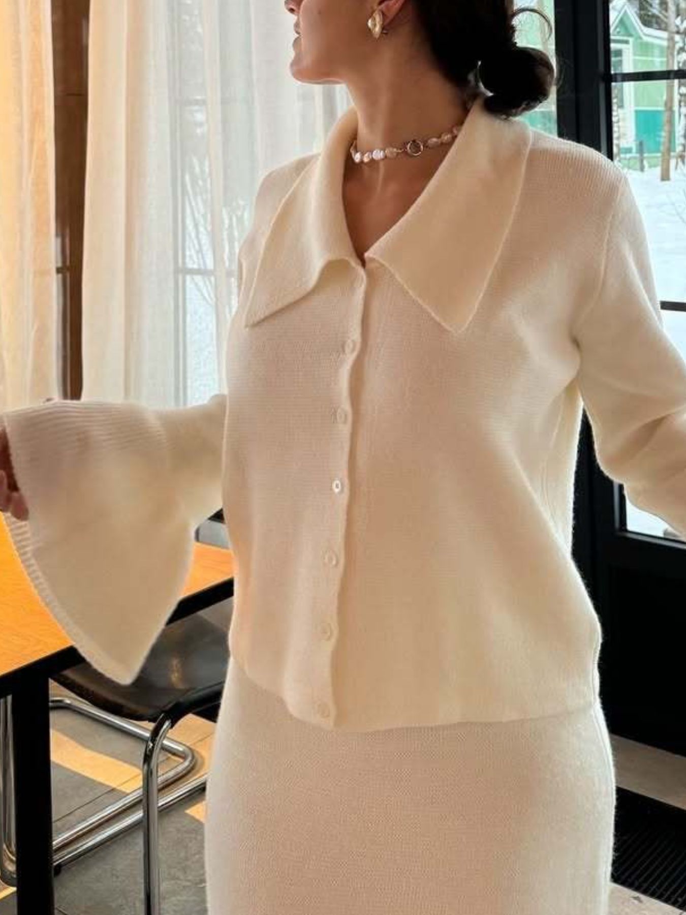 Button Down Cardigan and Skirt Knit Set worn by a woman in an elegant indoor setting featuring ribbed details.