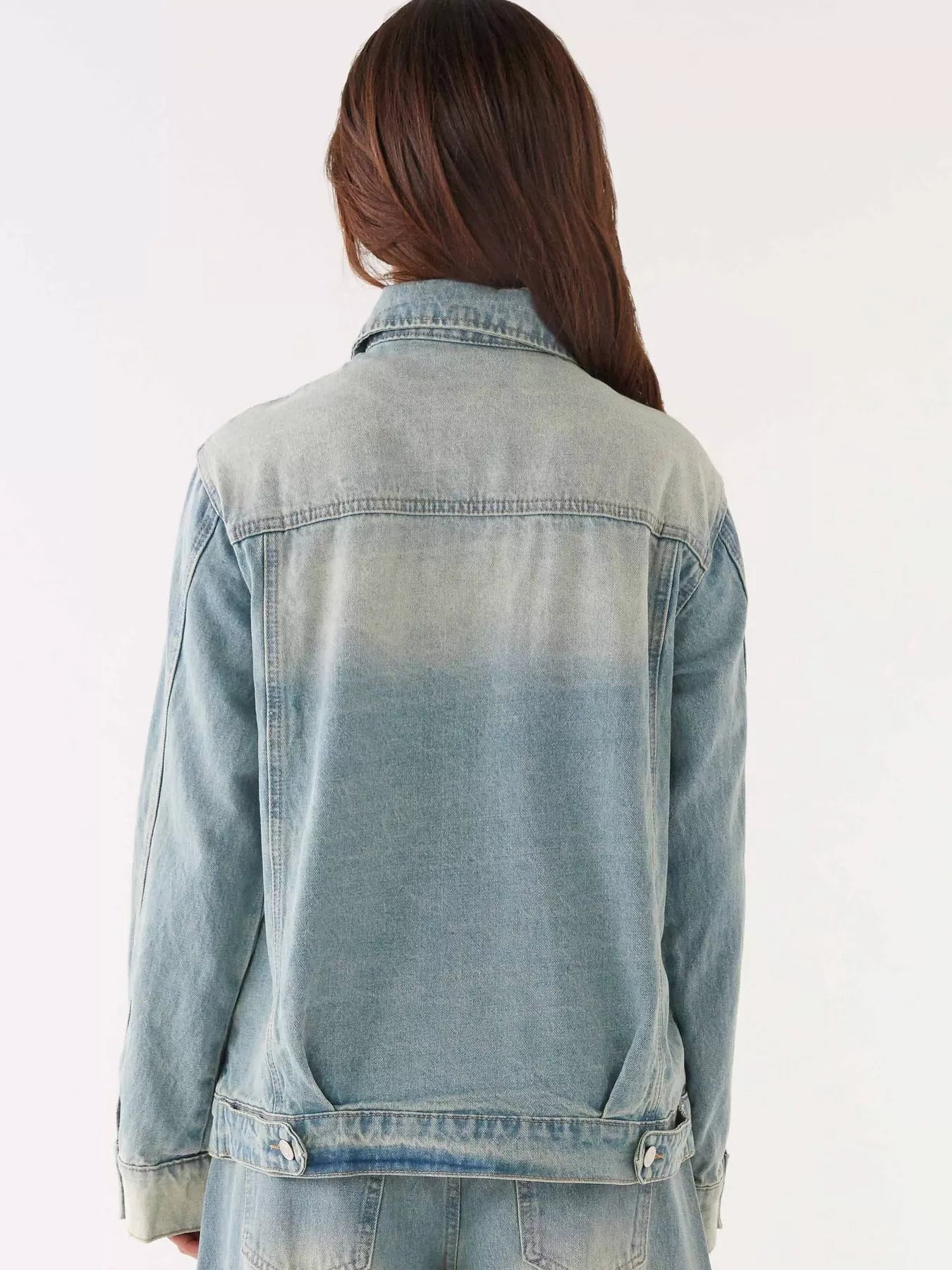 Back view of a model wearing a Button Up Denim Jacket and Jeans Set, showcasing the denim jacket's design.