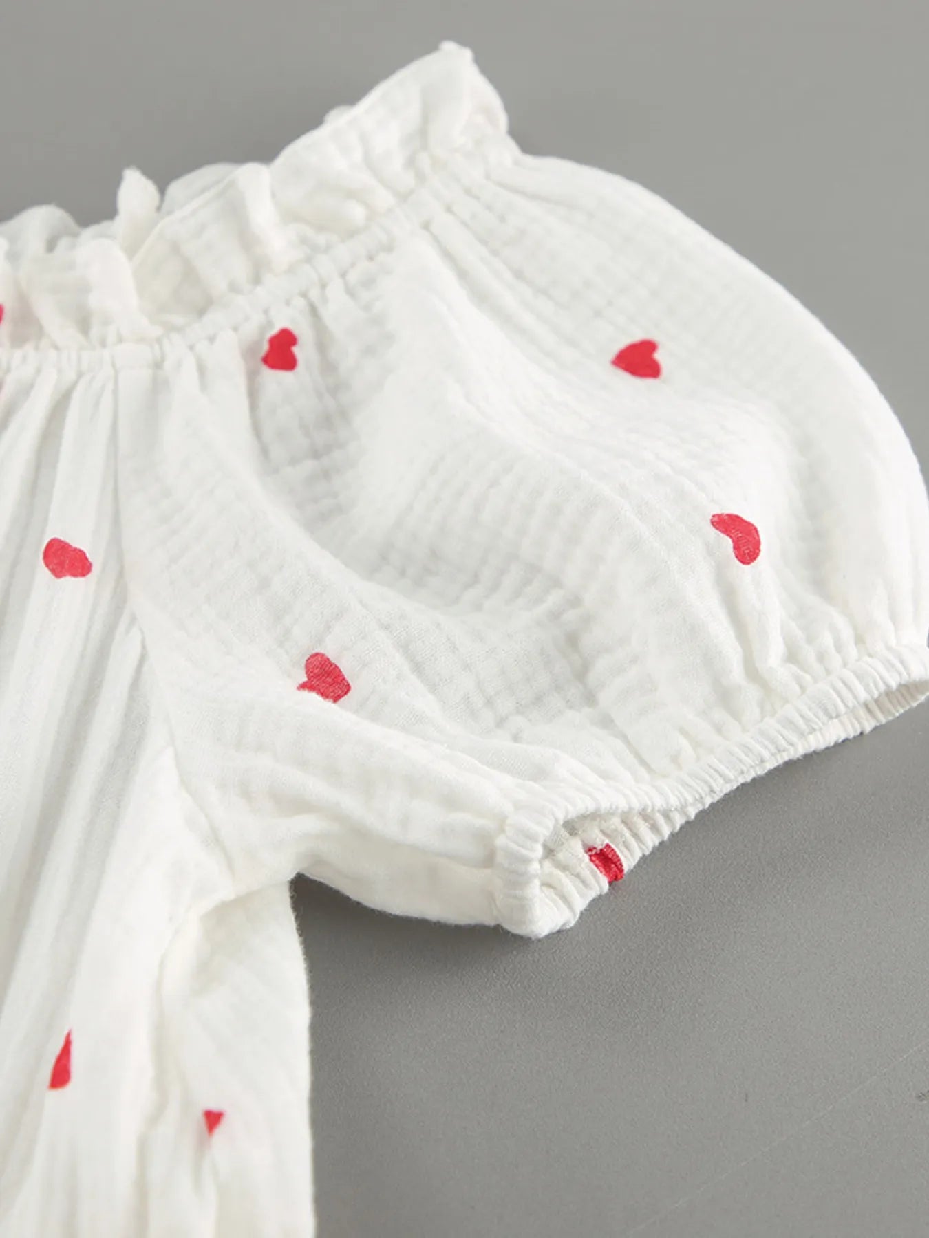 Heart Printed Off-Shoulder Ruffle Mini Dress featuring red heart prints and a frill neckline.