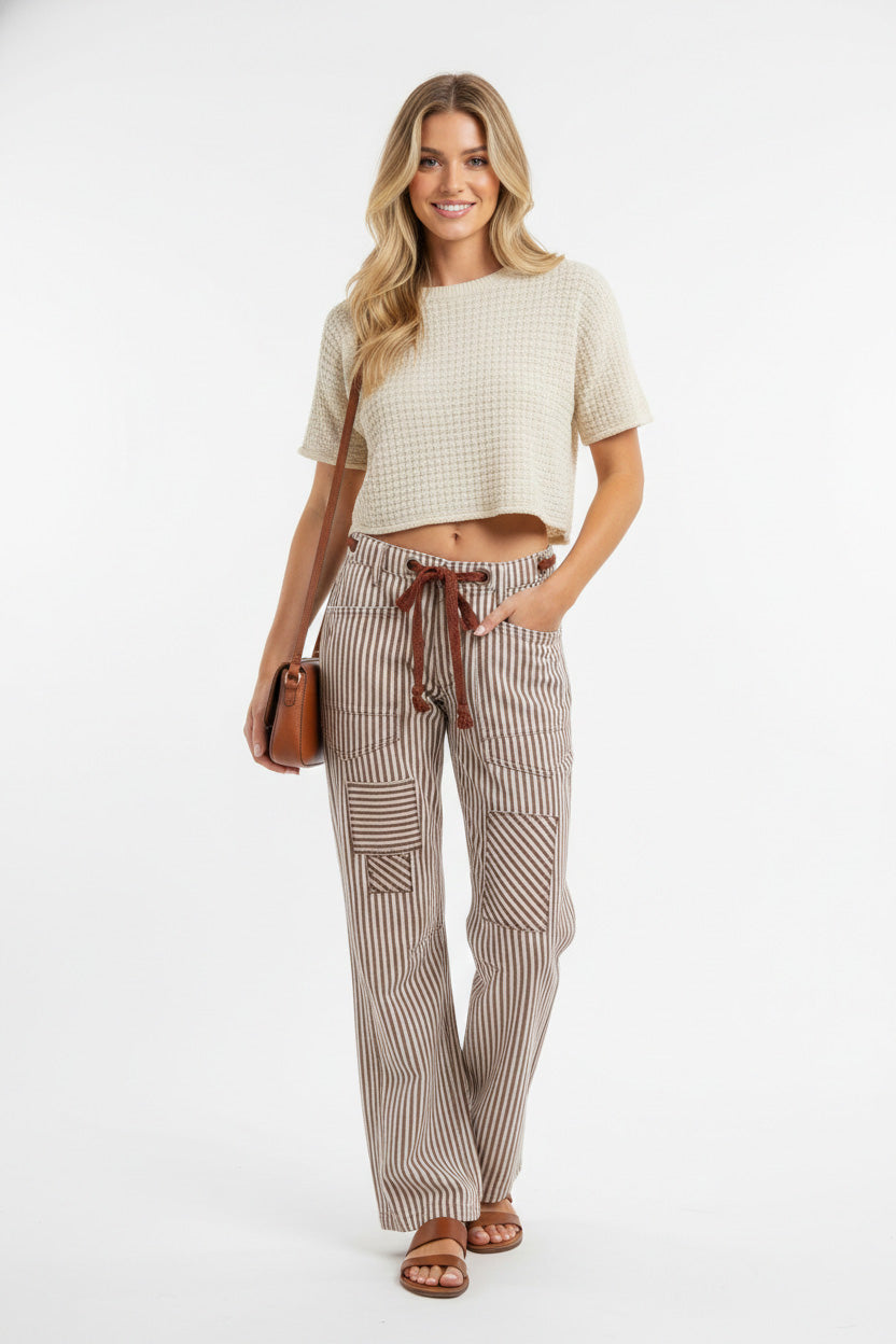 Woman wearing Drawstring Striped Twill Barrel Pants with a cozy top and holding a bag, showcasing a chic and relaxed style.