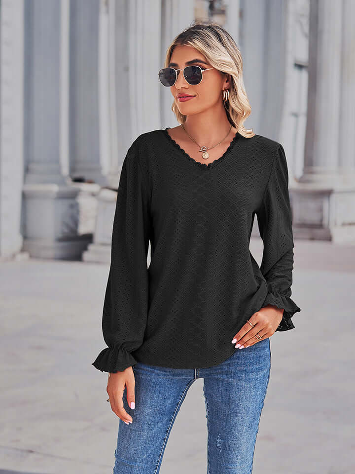 Eyelet V-Neck Flounce Sleeve Blouse in black worn by a woman with sunglasses outdoors.