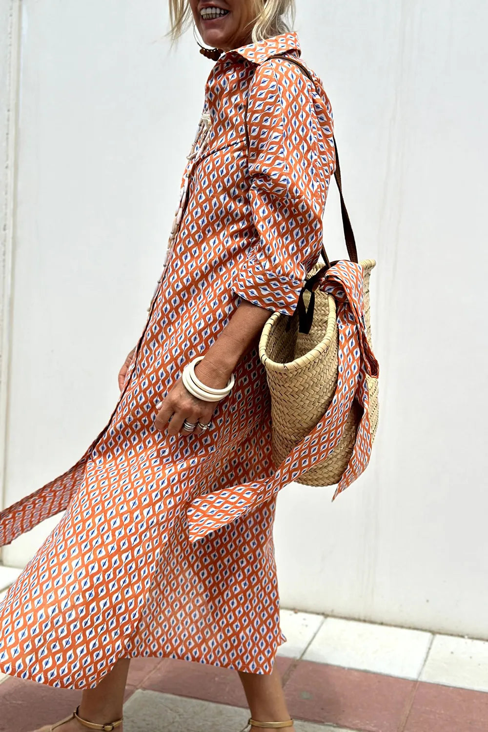 Tied Button Up Three-Quarter Sleeve Dress for Women in orange geometric print, model wearing with a straw bag.