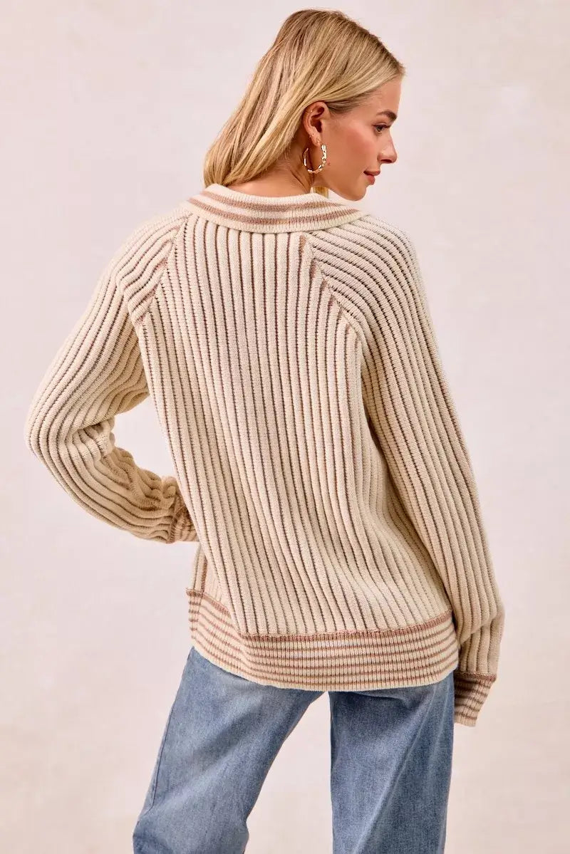 Back view of a woman wearing the BiBi half button ribbed two tone sweater in a stylish knit design.