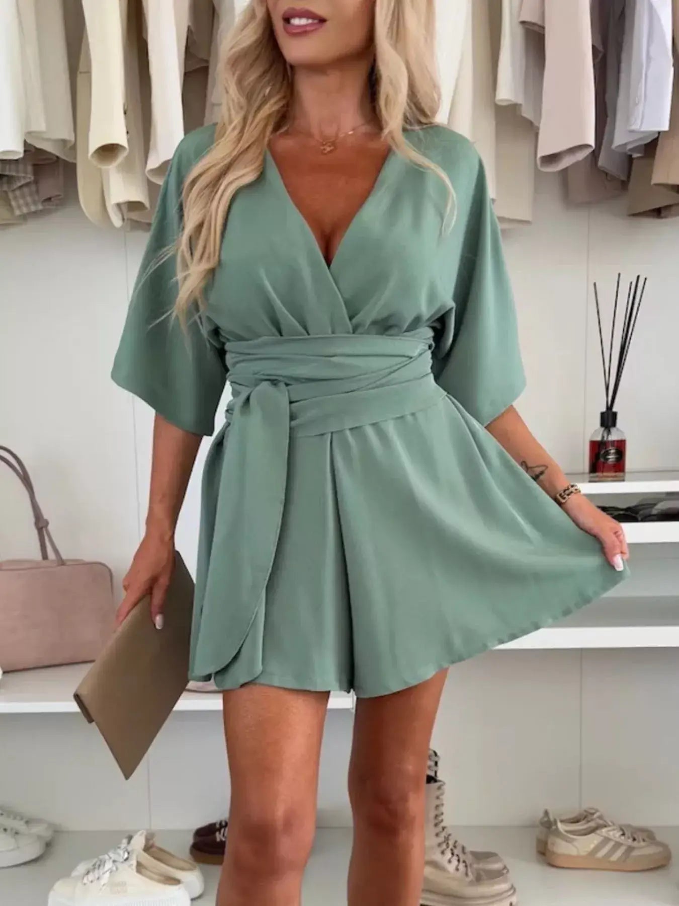 Full Size Surplice Tie Waist Romper in green worn by a model, featuring a surplice neckline and adjustable tie waist.