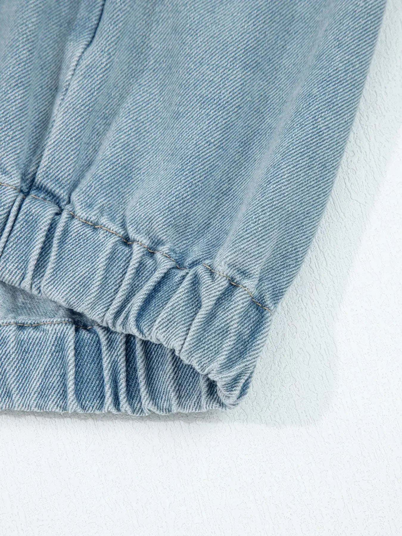 Close-up of the elastic edge cuff of a denim jacket, showcasing its snug fit and quality stitching.