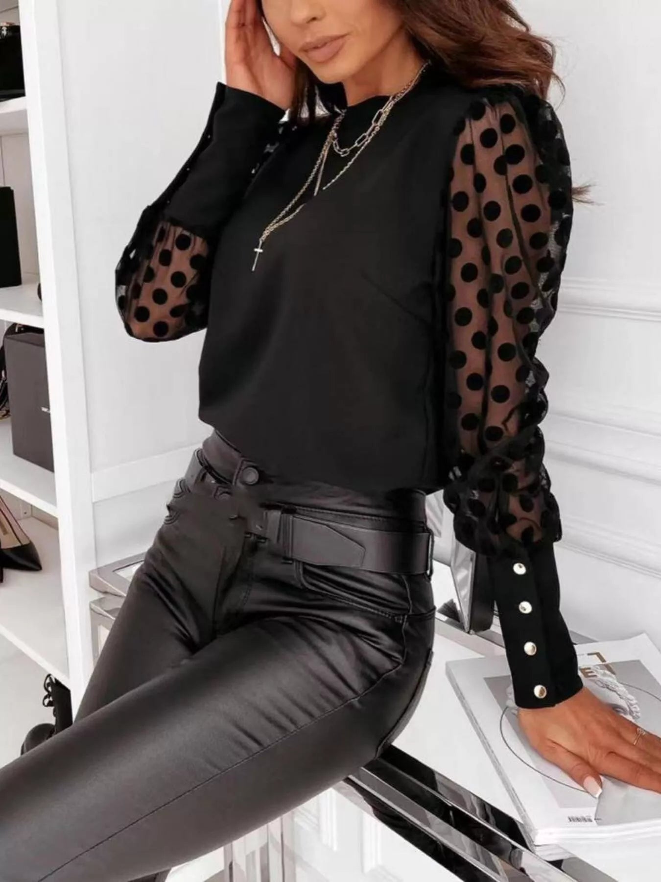 Polka Dot Mesh Sleeve Blouse elegant sheer top worn with black pants and layered necklaces, showcasing stylish polka dot mesh sleeves.