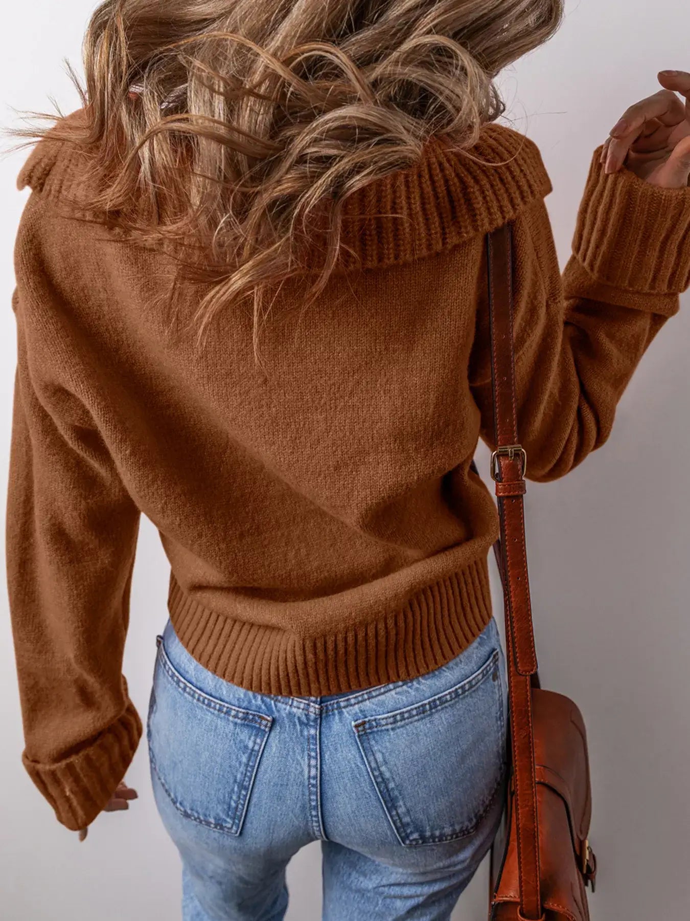 Back view of a woman wearing a collared v neck ribbed edge sweater in brown paired with jeans.