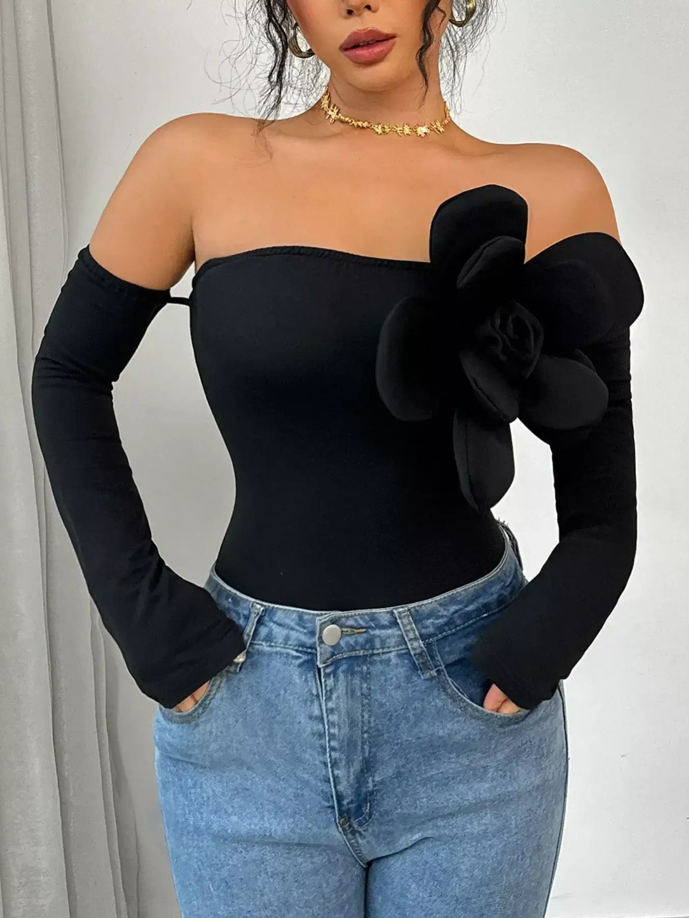 Flower off-shoulder long sleeve bodysuit featuring a statement floral detail and long fitted sleeves.