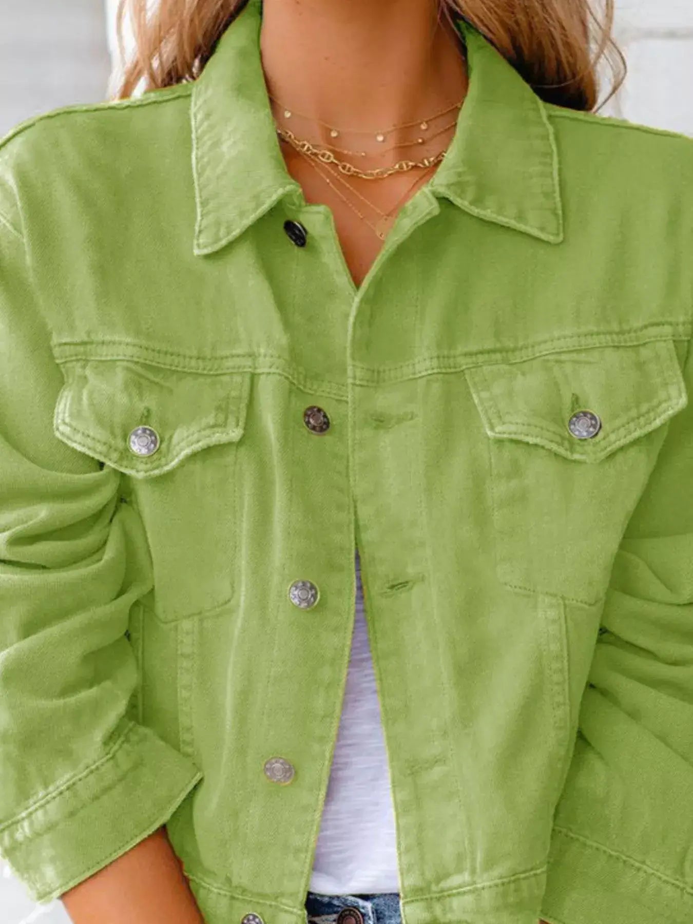 Women’s green button-up denim jacket featuring long sleeves and classic collar design.