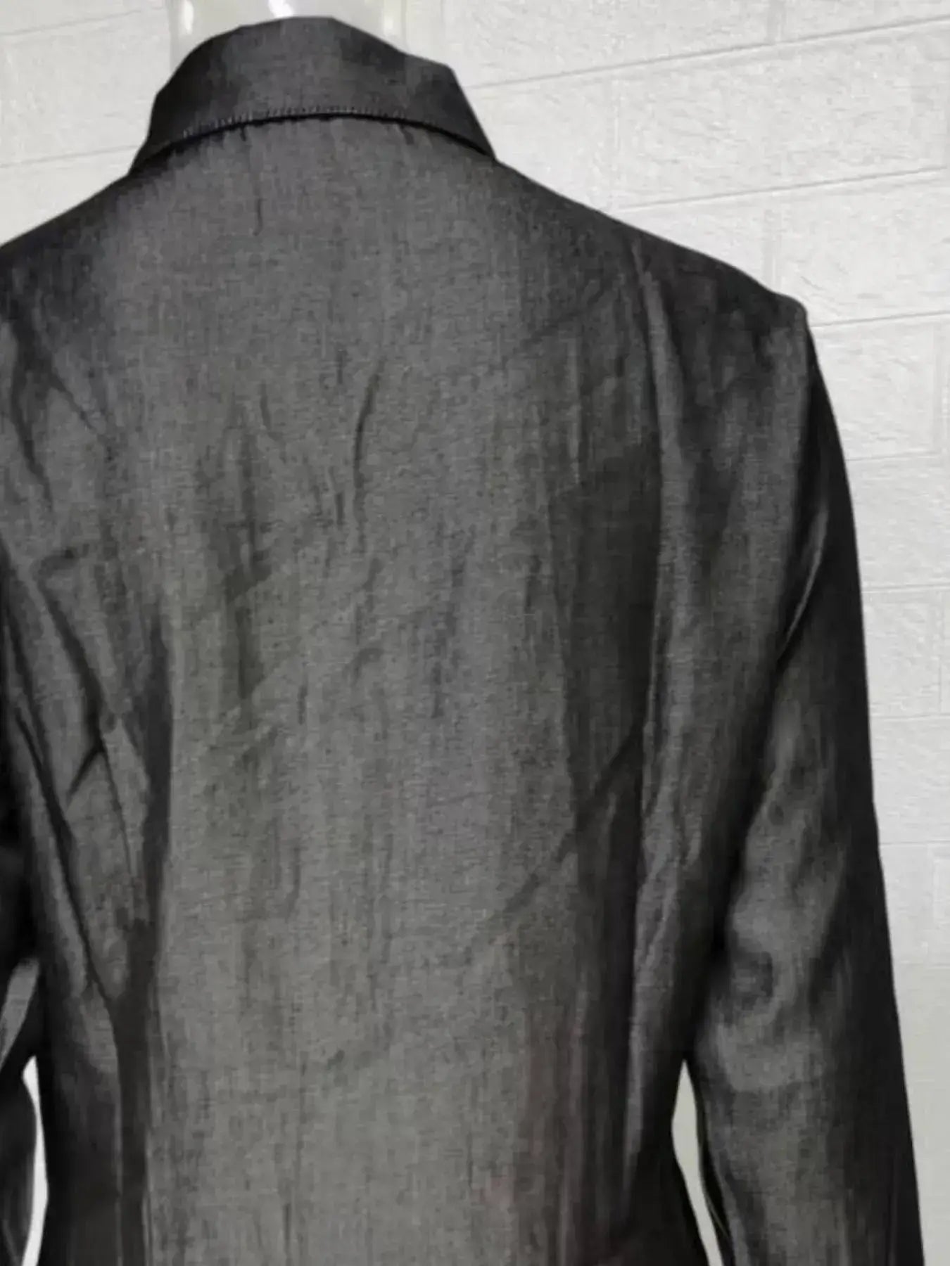 Back view of a stylish black dress showcasing its sleek fabric and collar design.