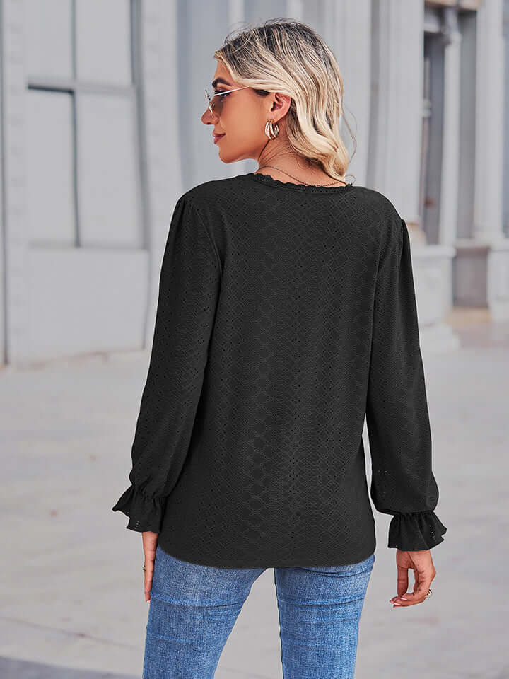Back view of a woman wearing the Eyelet V-Neck Flounce Sleeve Blouse in black, showcasing flounce sleeves and elegant design.